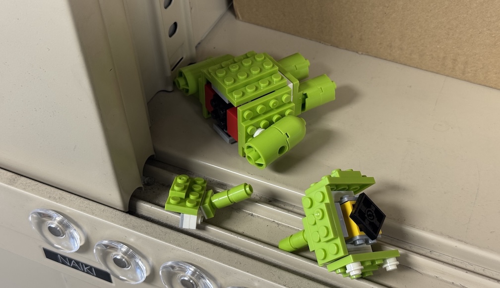 Broken Lego Android droid parts scattered on the shelf after earthquake